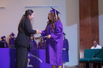teacher and student shaking hands in graduation
