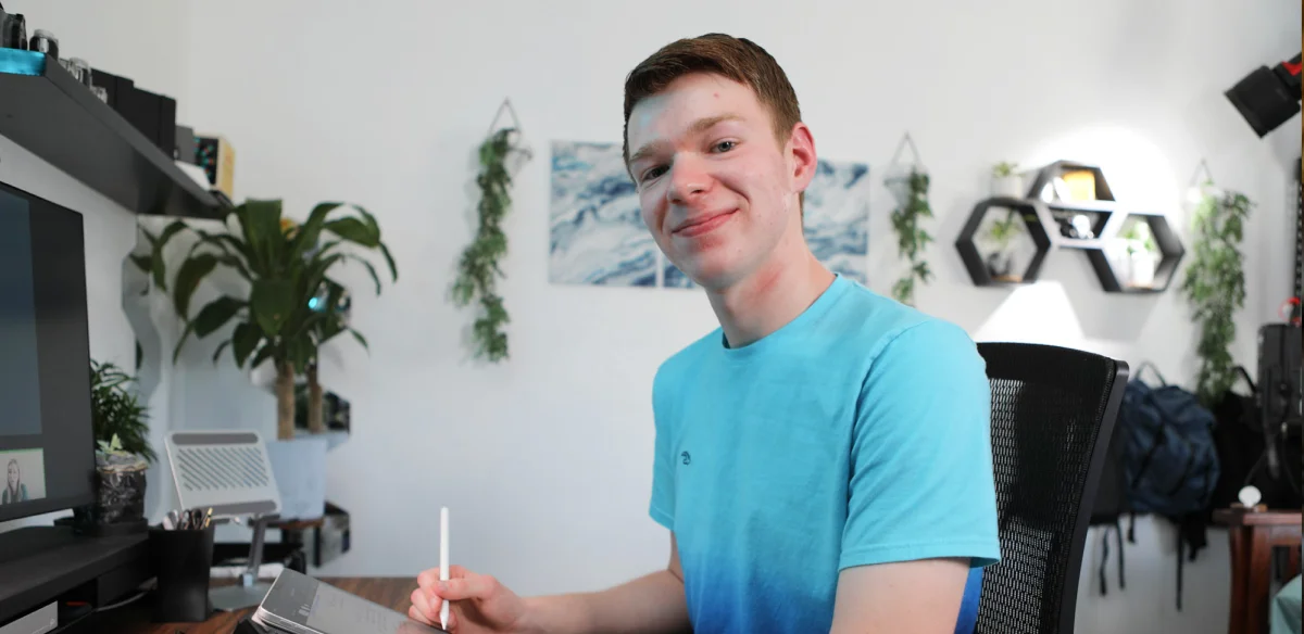 High School sutdent wearing a light blue shirt and taking notes at home